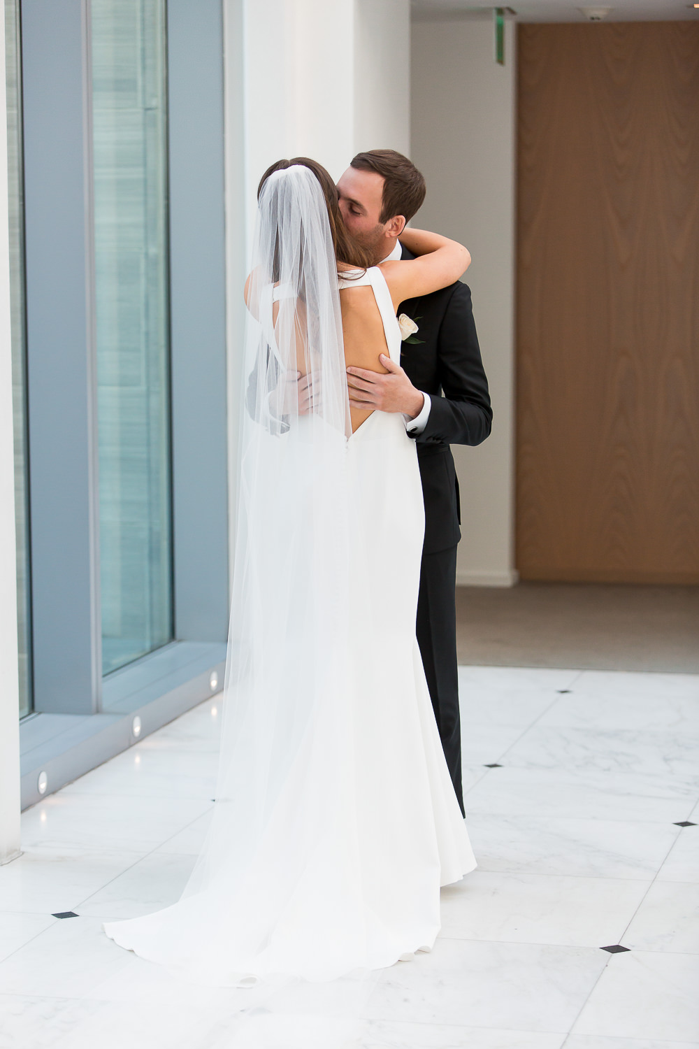 A couple kissing in the lobby at the Edition on Miami Beach during their first look.