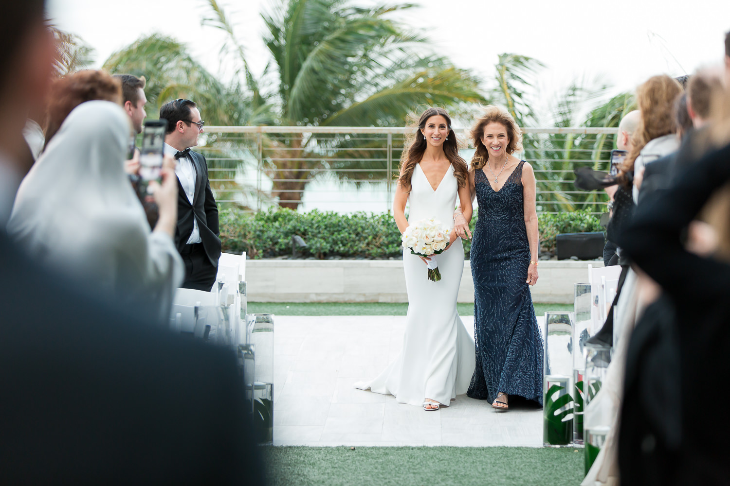 A bride walks down the aisle with her mom at the Miami Beach Edition.