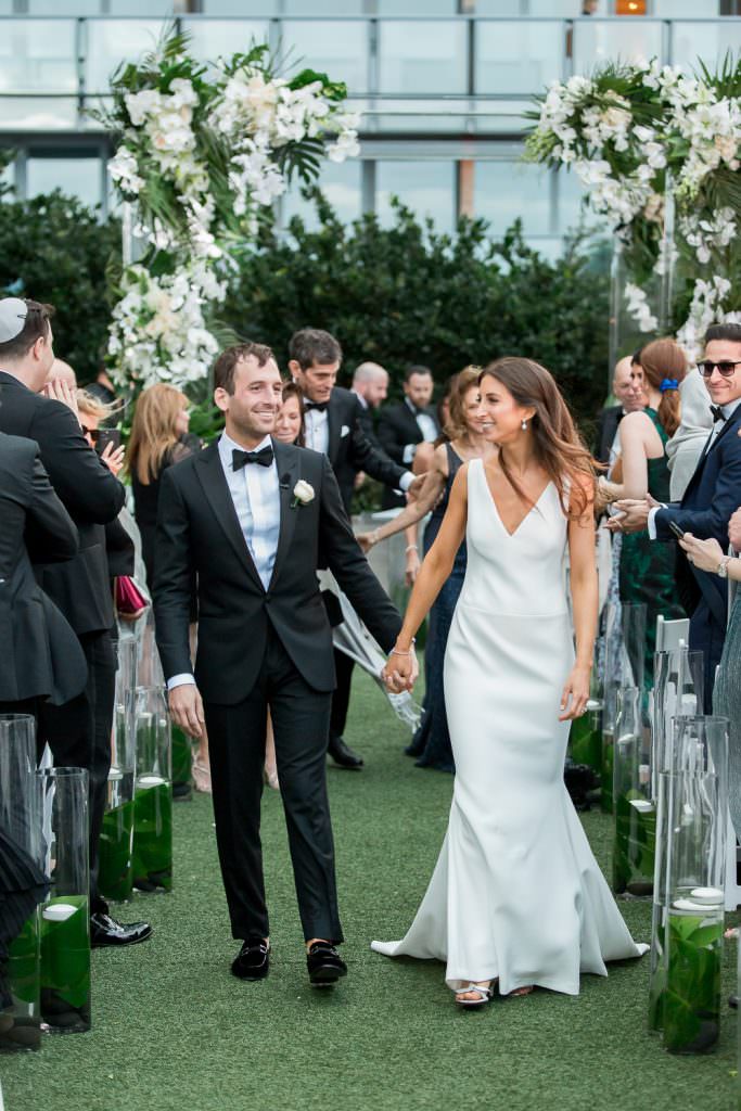 Bride and groom walk down the aisle hand in hand after their wedding ceremony at the Miami Beach Edition.