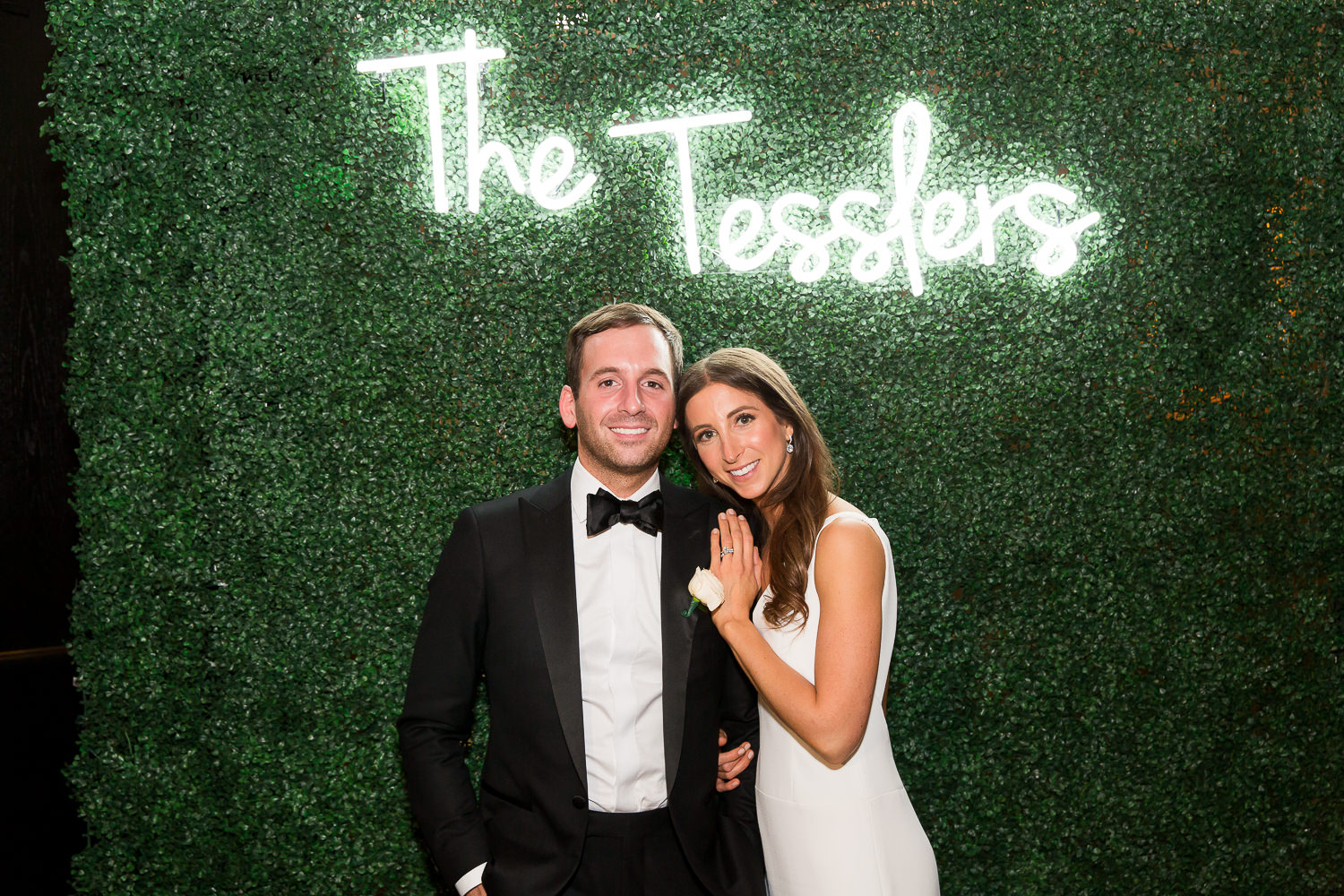 Bride and groom pose under a neon sign during their wedding at the Edition on Miami Beach.