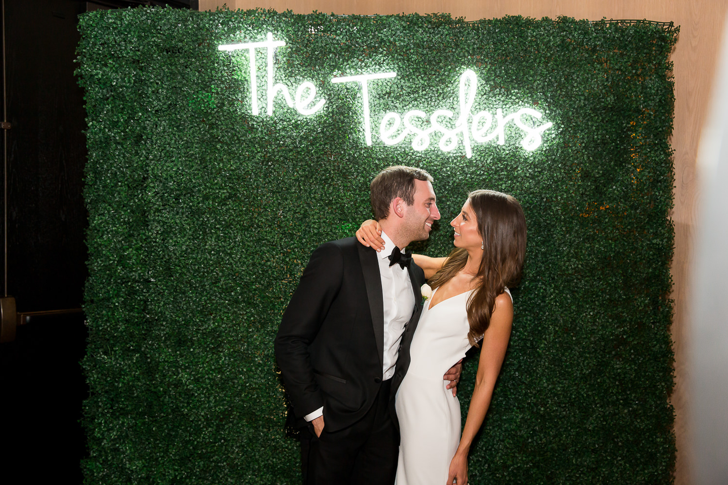 Bride and groom under a neon sign during their wedding at the Edition on Miami Beach.