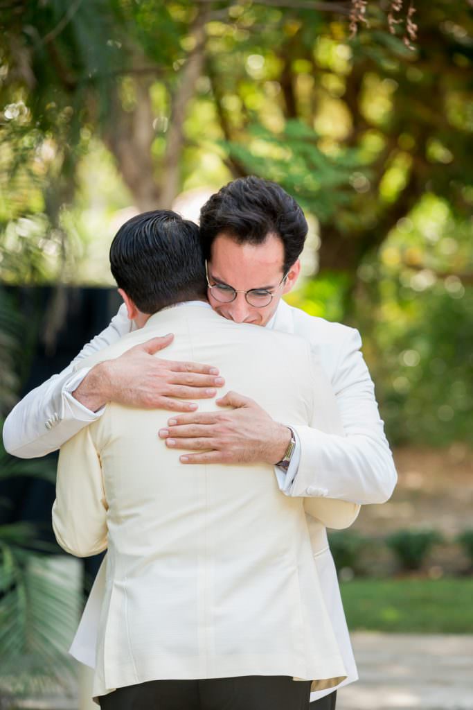 Two grooms share a first look during their wedding at their family home in Miami.