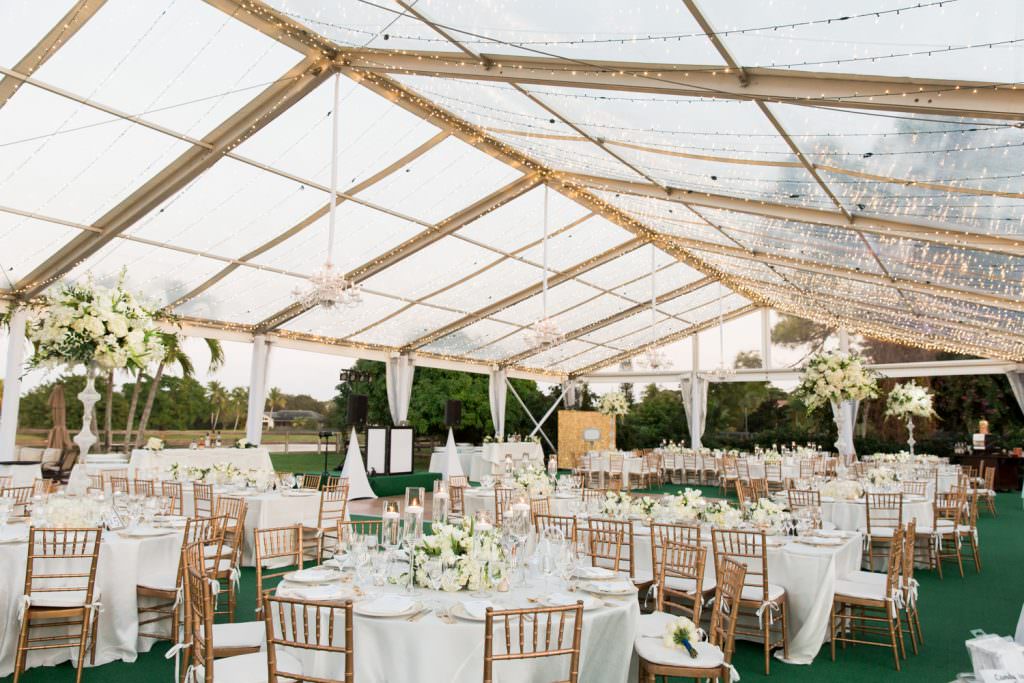 White and green wedding decor in a clear tent during a backyard wedding in Palm Beach..