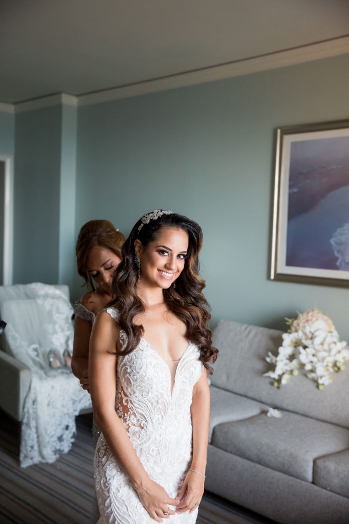 bride is helped into her wedding dress by her bridesmaids