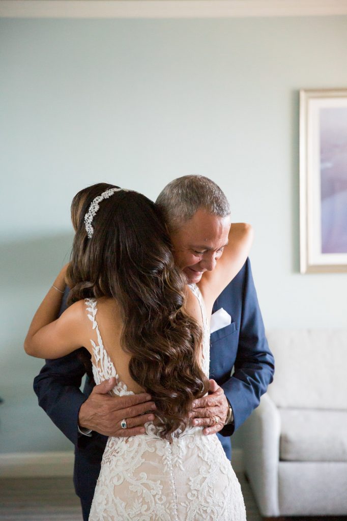 Dad hugs his daughter after seeing her in her wedding dress