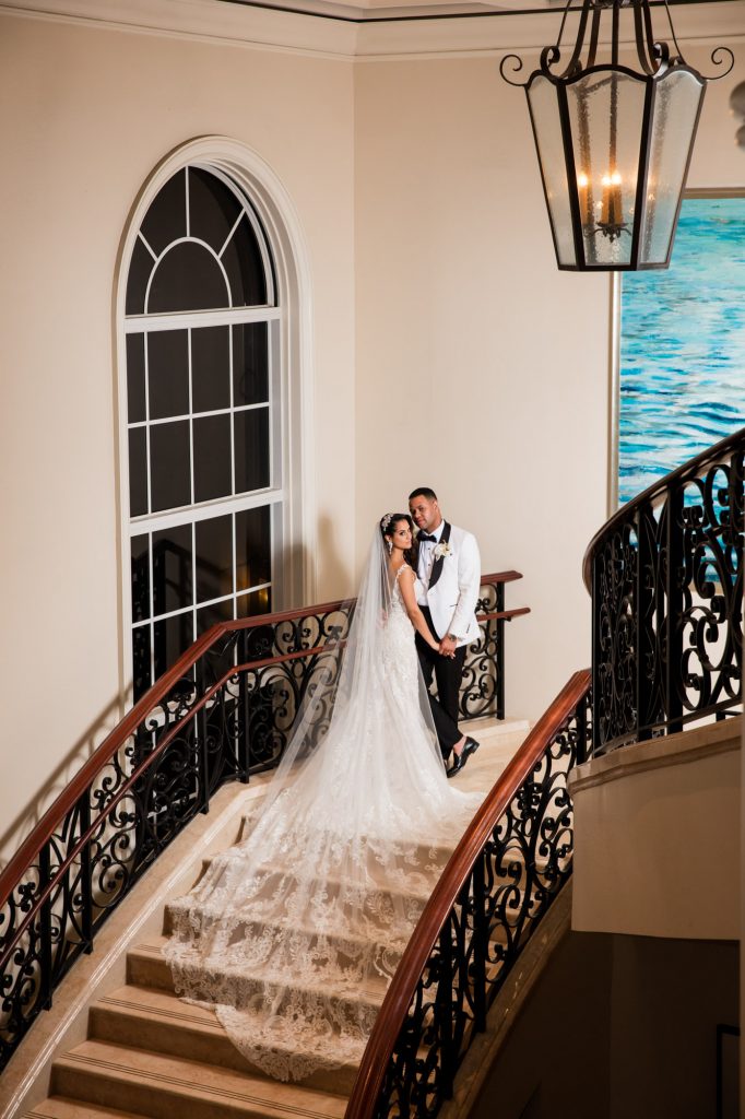 bride and groom pose for a photo at the top of the stairs at the RitZ-Carlton Key Biscayne