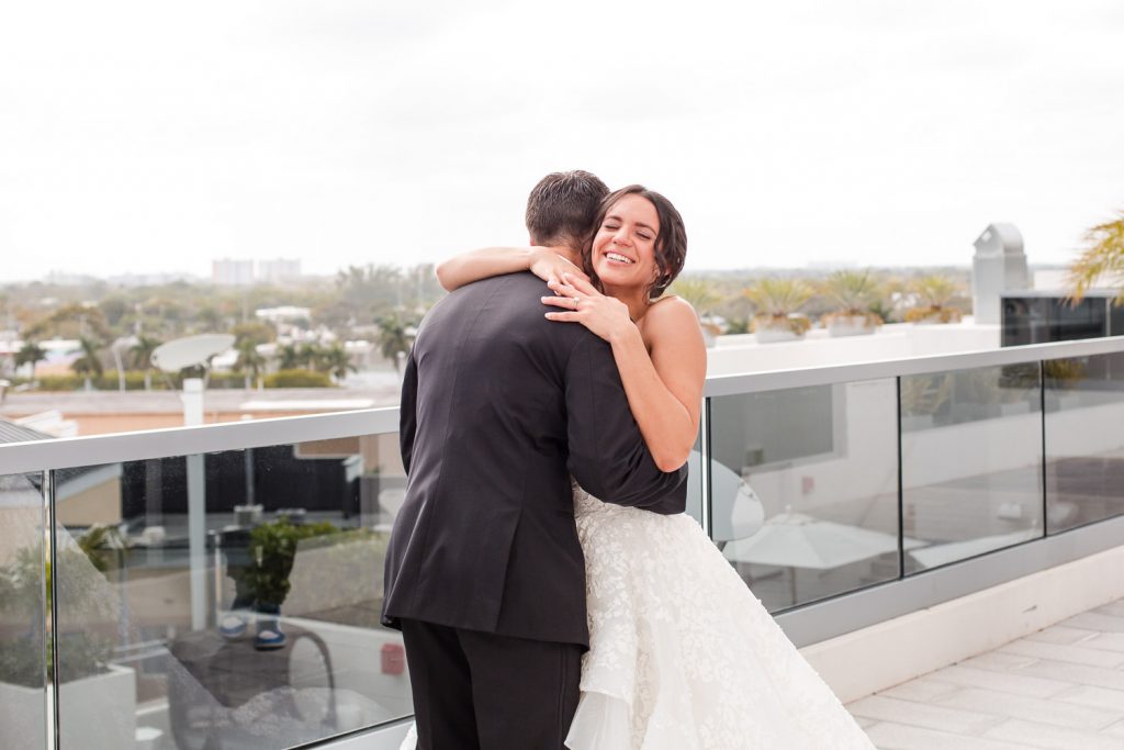 A bride and groom hug during their first look at their wedding in Aventura.