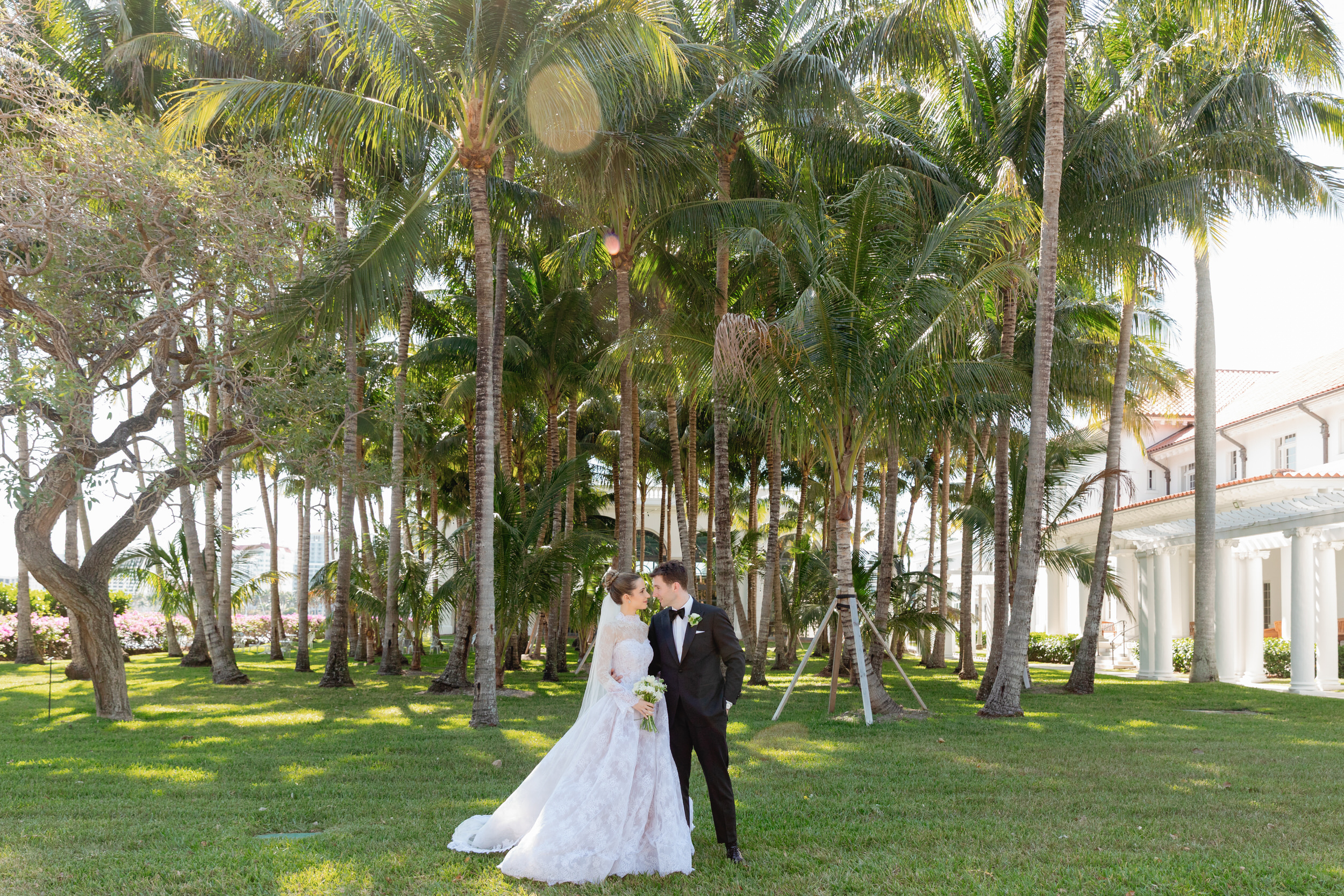 Bride and groom infront of the Flagler Museum Palm tree grove.
