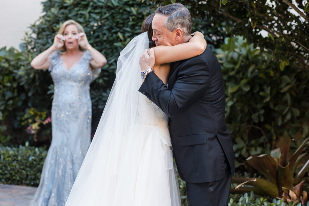 Mother of bride wiping away a tear during the father of bride first look.