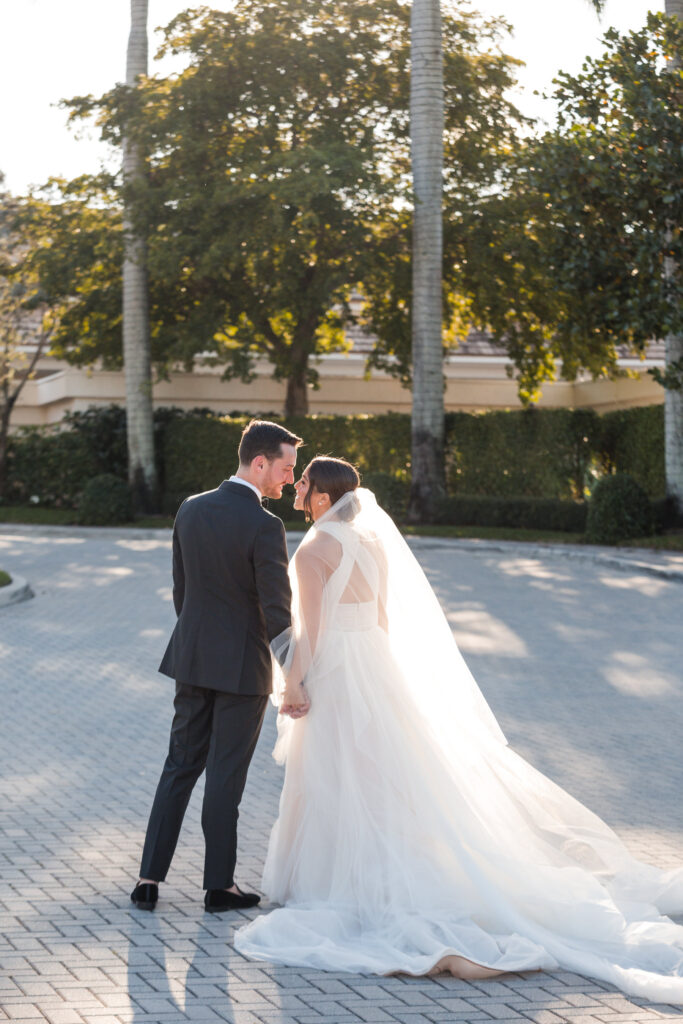 Bride and groom embracing during golden hour on the Polo Club Boca Raton golf course