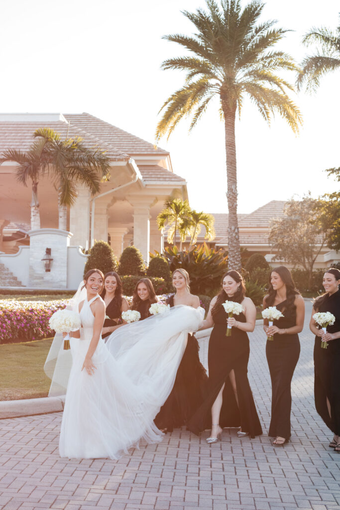 Bridesmaids laughing together in black dresses during wedding day portraits at the Polo Club