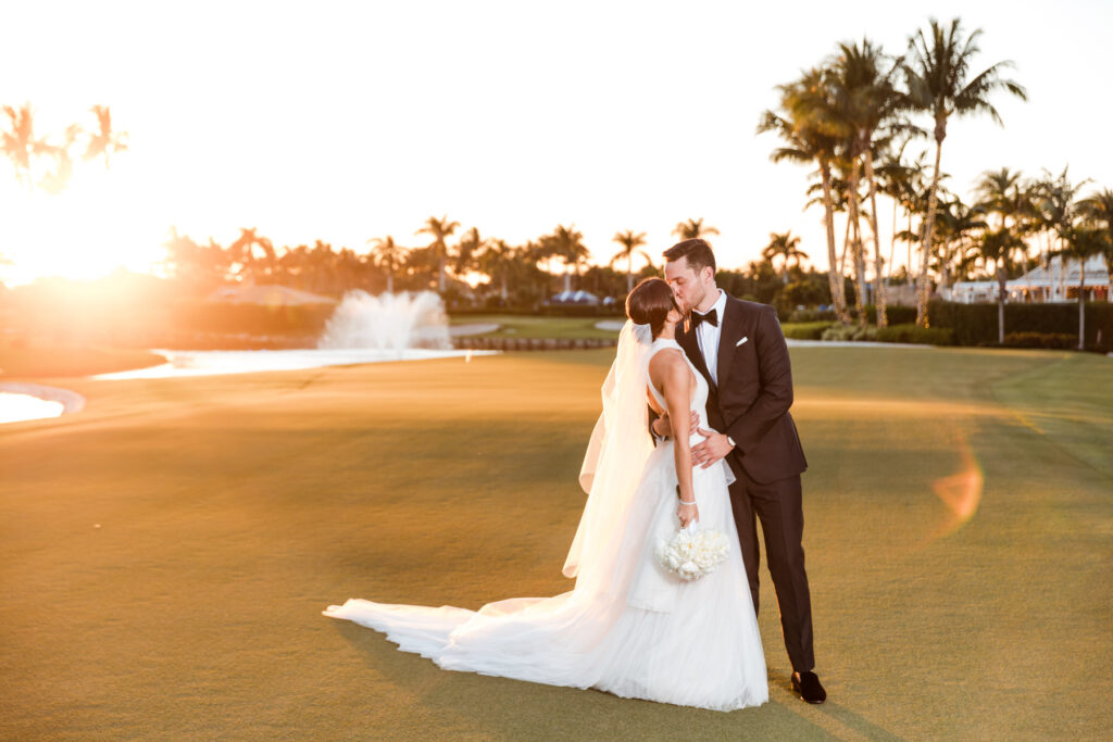 Bride and groom embracing during golden hour on the Polo Club Boca Raton golf course