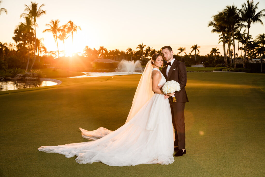 Timeless wedding portrait of bride and groom with glowing sunset light behind them