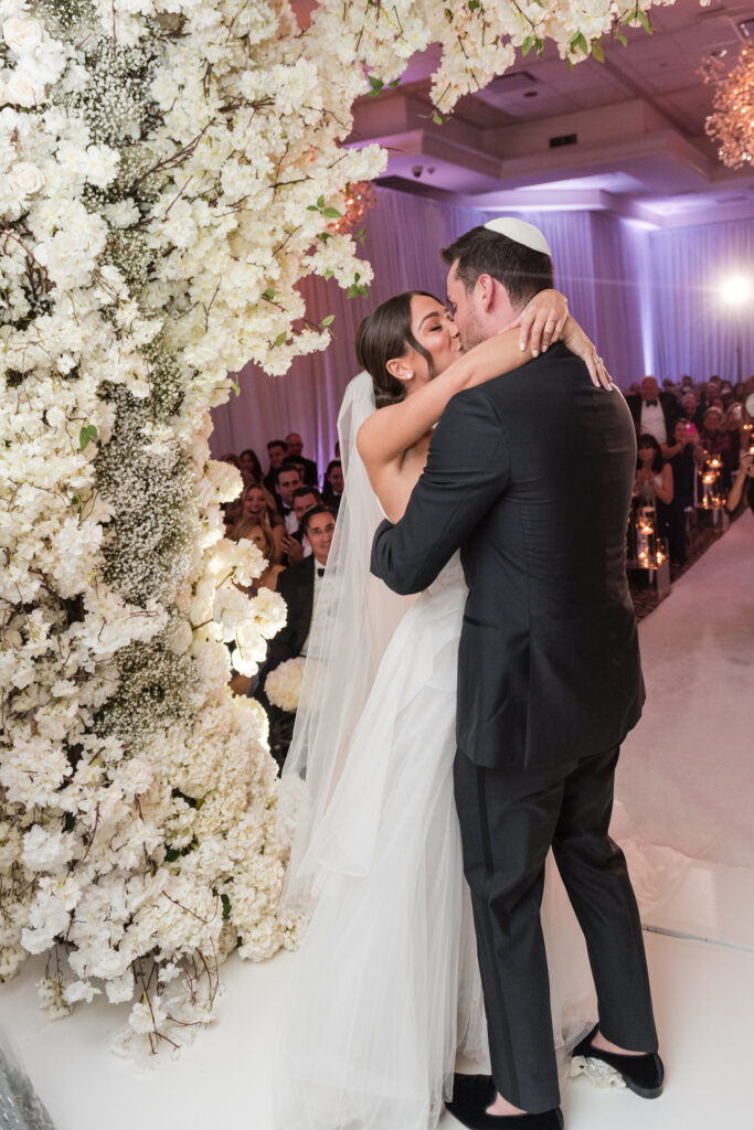 Bride and groom exchanging vows under the chuppah at the Polo Club
