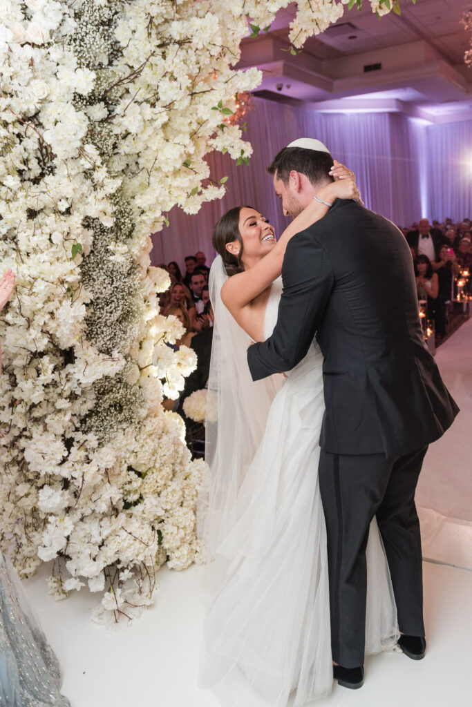 Tender moment as couple smiles at each other during outdoor chuppah ceremony