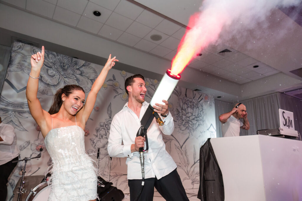 High-energy dance floor moment as bride and groom dance with CO₂ cannon effects