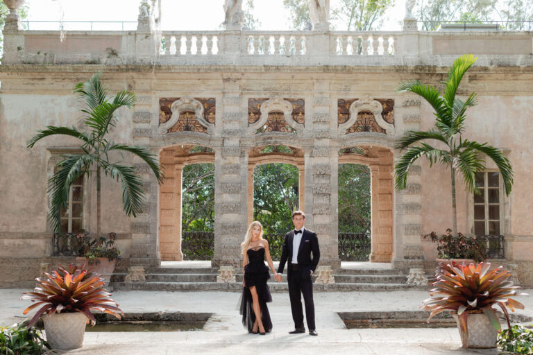 Engaged couple on the steps of Vizcaya in fomral black dress and tuxedo.