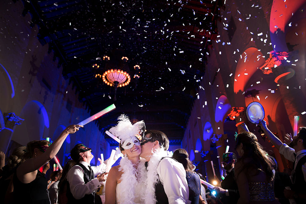Groom kissing bride on the cheek in the Country Club ballroom at the Biltmore Hotel.
