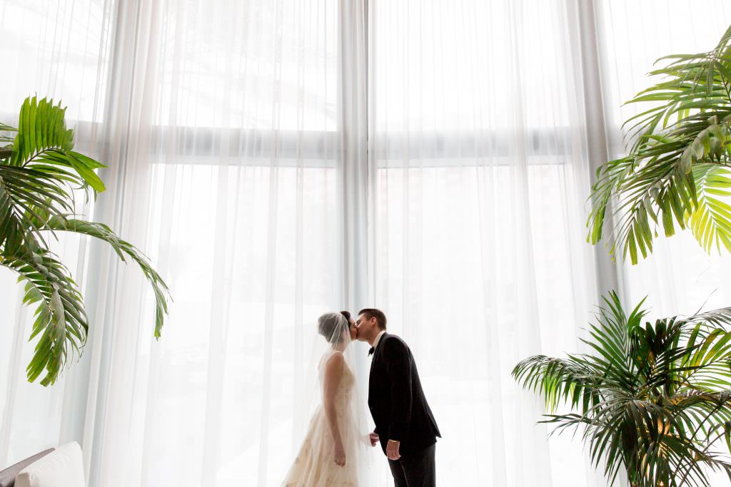 Couple kissing in the lobby during their wedding at the Miami Beach Edition.