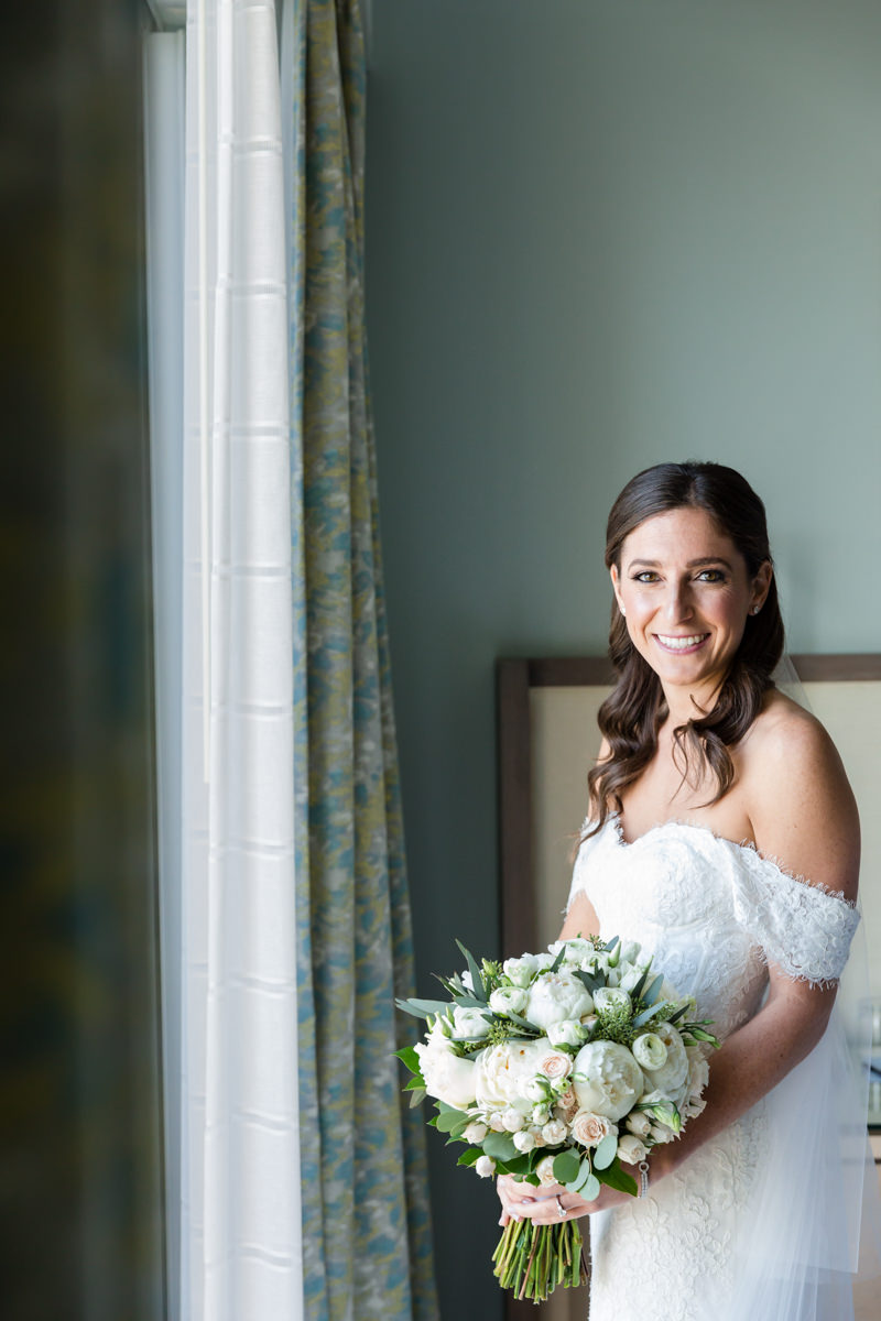 Bride smiling after putting on her veil in the bridal suite at the Ritz Carlton Key Biscayne.