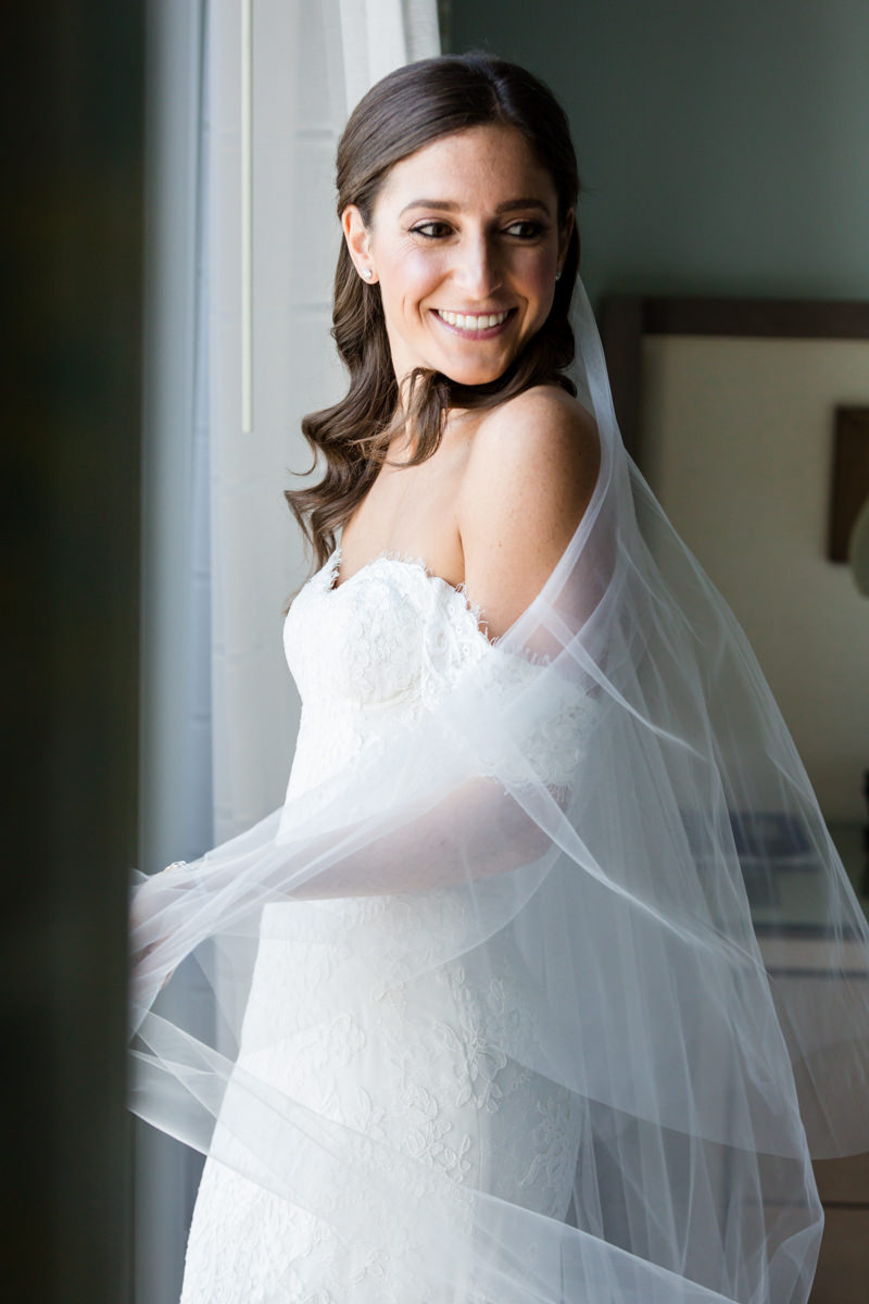 Bride smiling after putting on her veil in the bridal suite at the Ritz Carlton Key Biscayne.