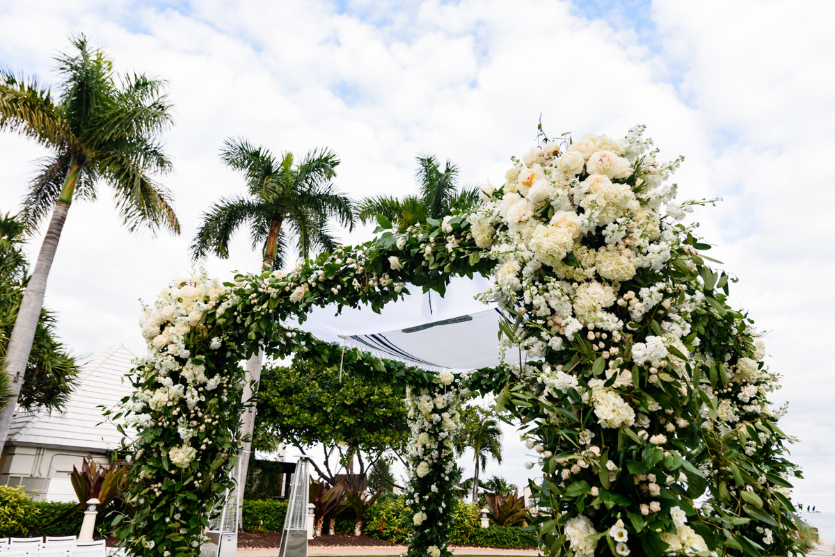 A white flower covered chuppah designed by Avante Gardens during a wedding at the Ritz Carlton on Key Biscayne.