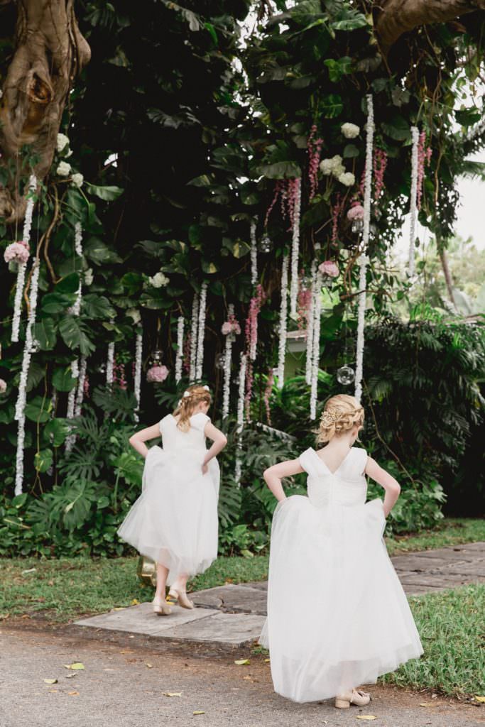 Two flower girls walk towards their family home in Miami during a wedding.