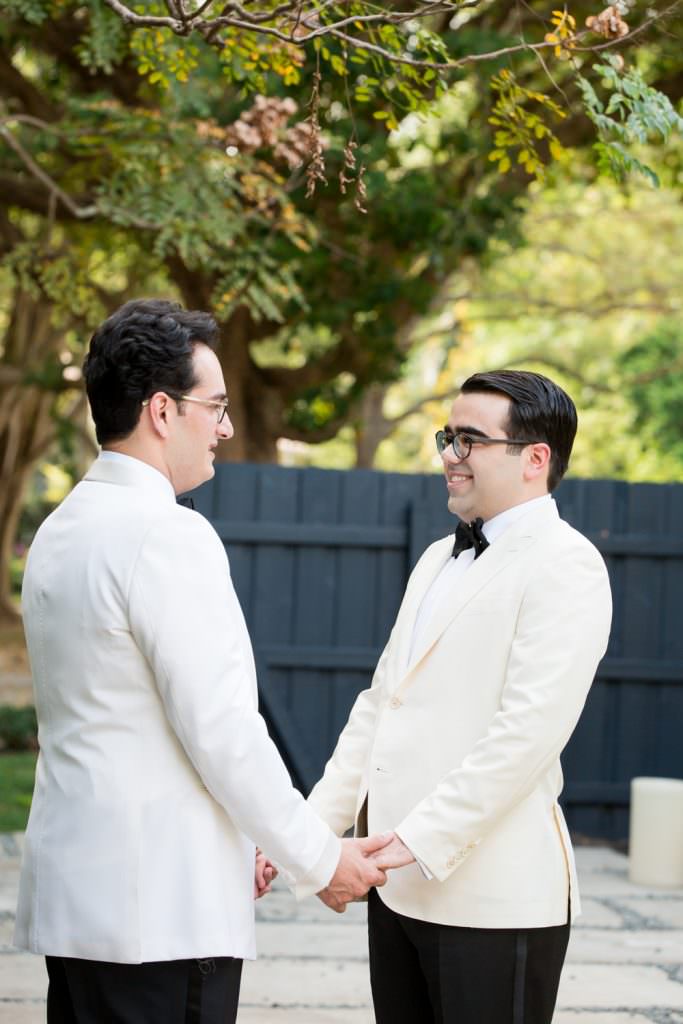 Two grooms share a first look during their wedding at their family home in Miami.