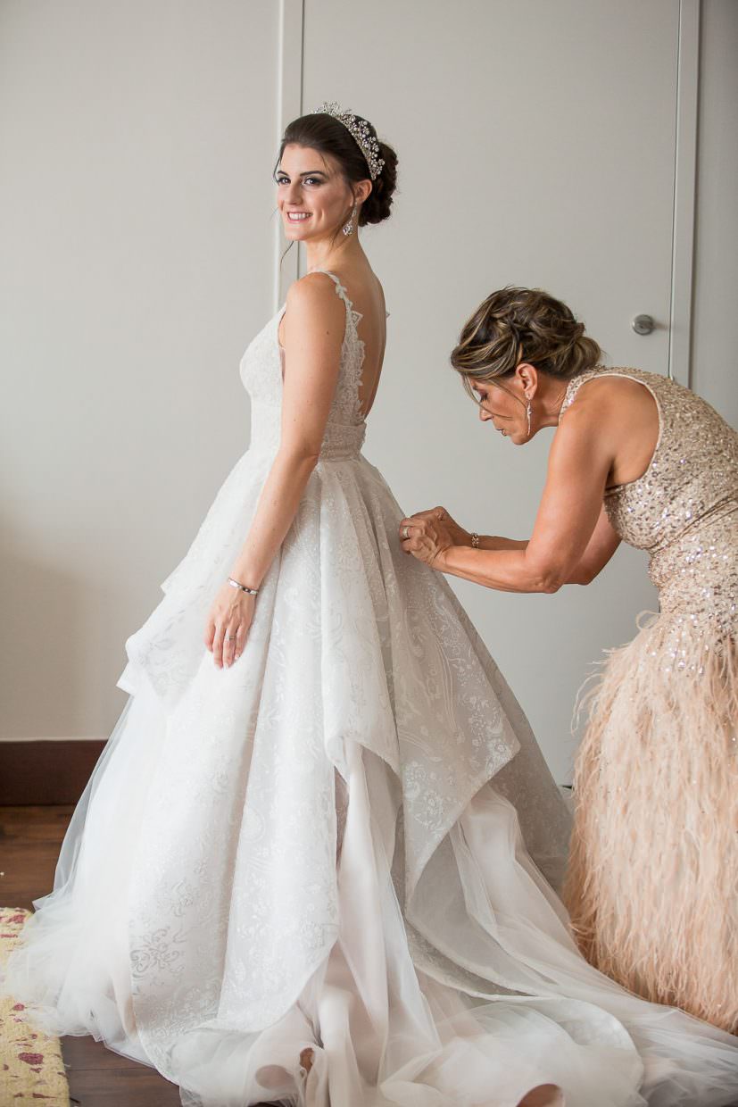 Mother of the bride helps button the brides dress at the Mandarin Oriental in Brickell Key.