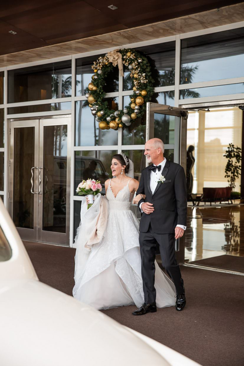 Father of the bride escorts his daughter to a vintage rolls royce in Miami Beach.