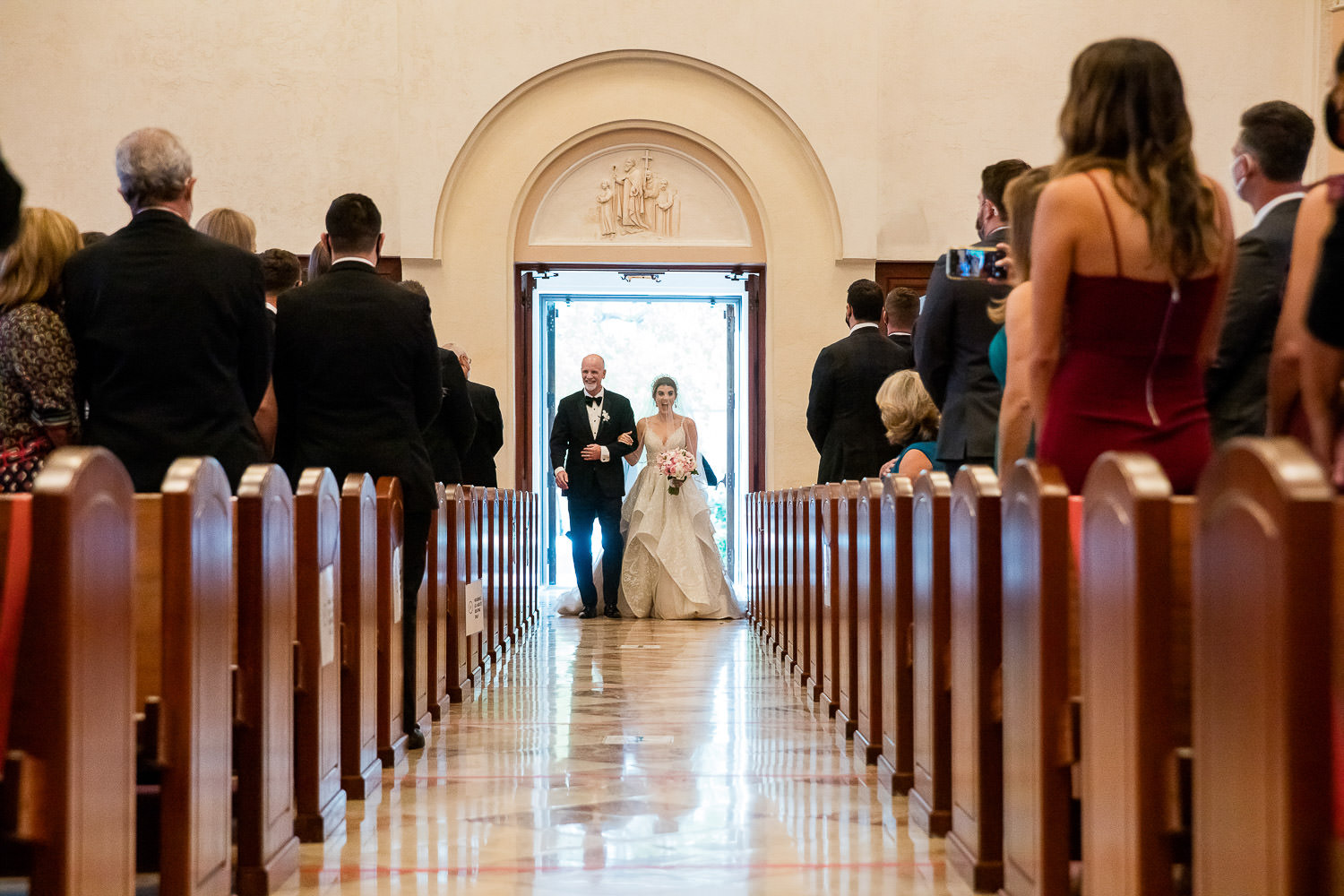 Father of the bride escorts his daughter into St Patrick's church in Miami Beach.