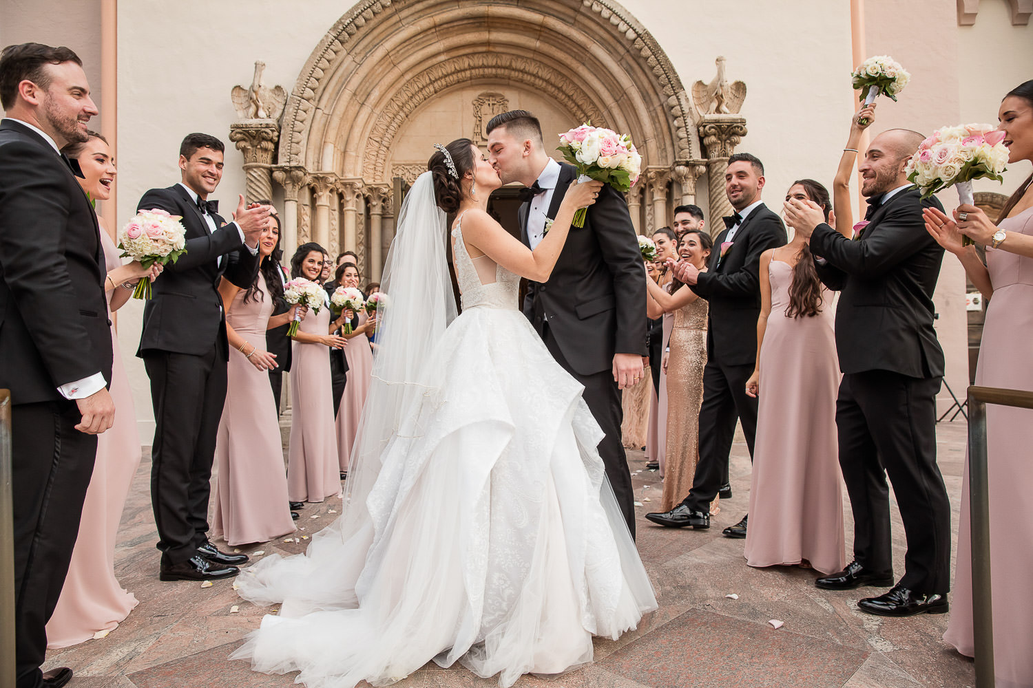 Wedding party poses for a portrait on the steps of St. Patrick's church in Miami Beach.