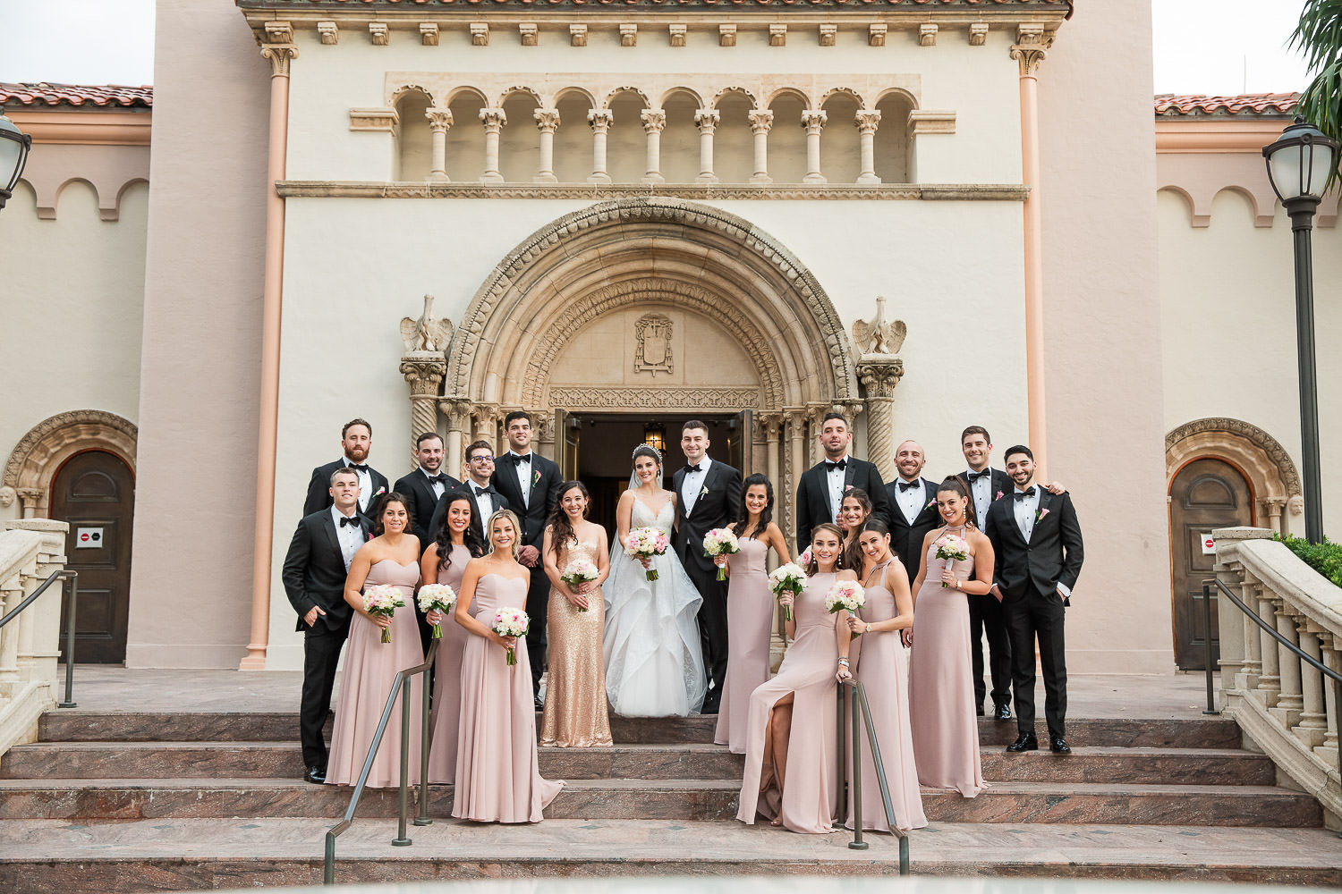 Wedding party poses for a portrait on the steps of St. Patrick's church in Miami Beach.