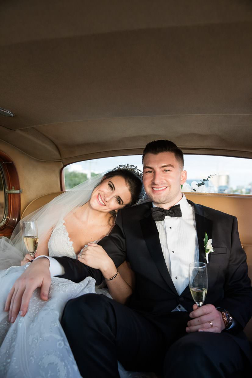 Bride and groom riding in a classic Rolls Royce on their way to their wedding at the Mandarin Oriental.