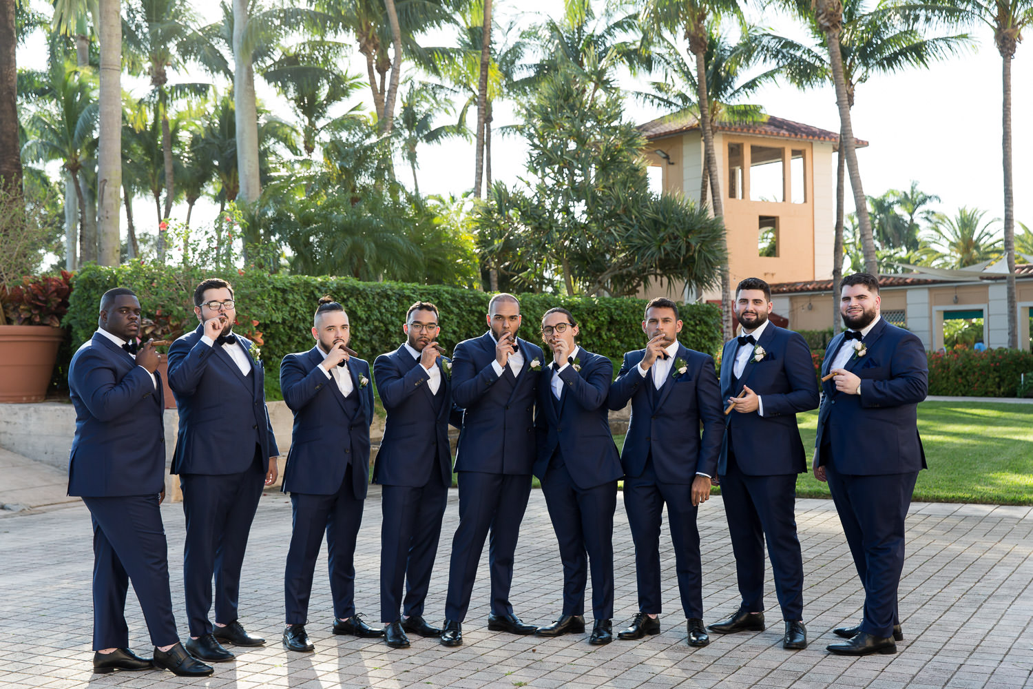 Groomsmen pose with cigars at the Biltmore hotel during a wedding.