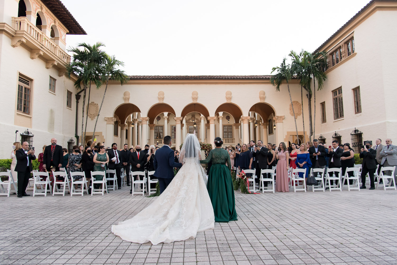 Bride walks down the aisle during a wedding at the Biltmore Hotel in Miami.