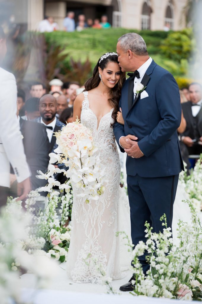 Dad hugs his daughter as they walk down the aisle together