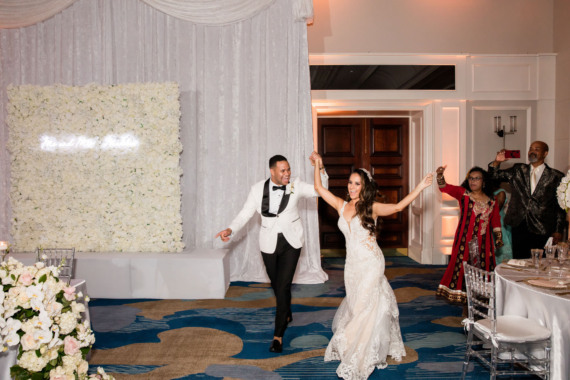 bride and groom enter the evening reception room to have their first dance