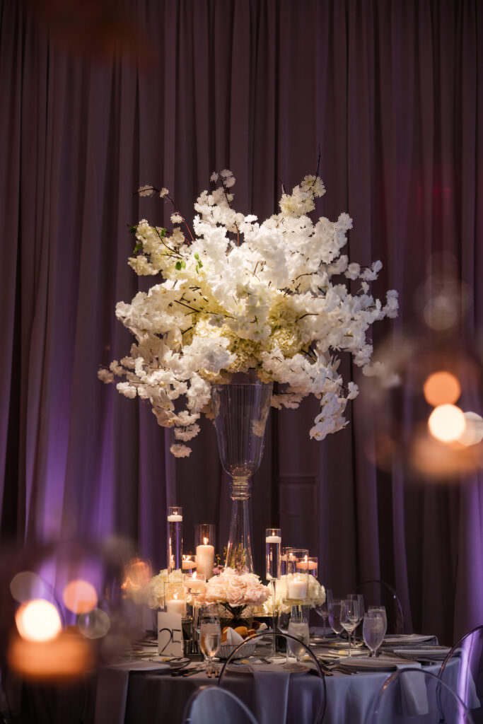 Elegant reception table set with white linens and candlelight
