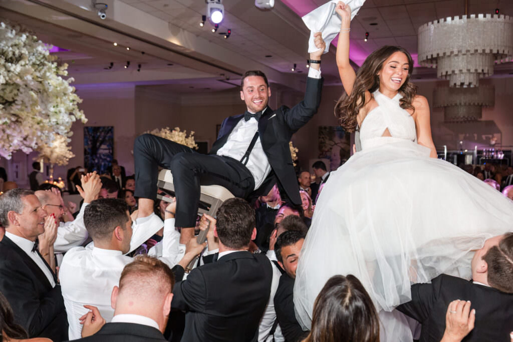 Joyful hora as bride and groom are lifted in chairs during Boca Raton wedding celebration