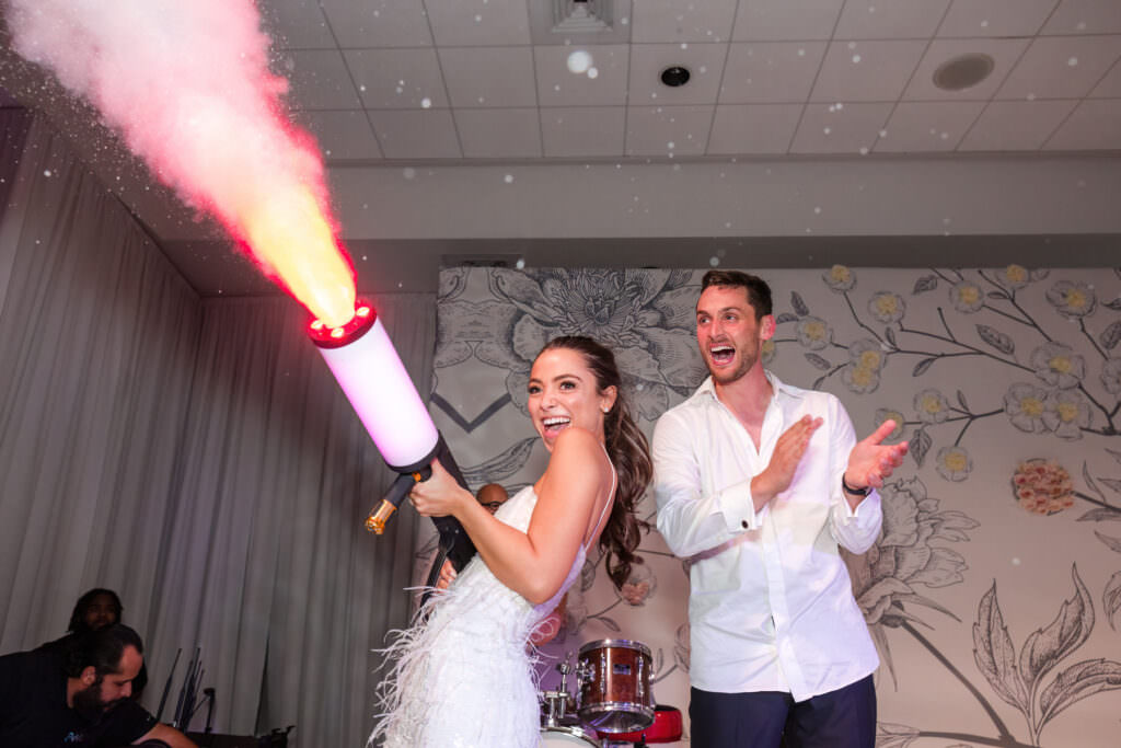 Bride and groom celebrating on the dance floor with CO₂ cannon during wedding reception