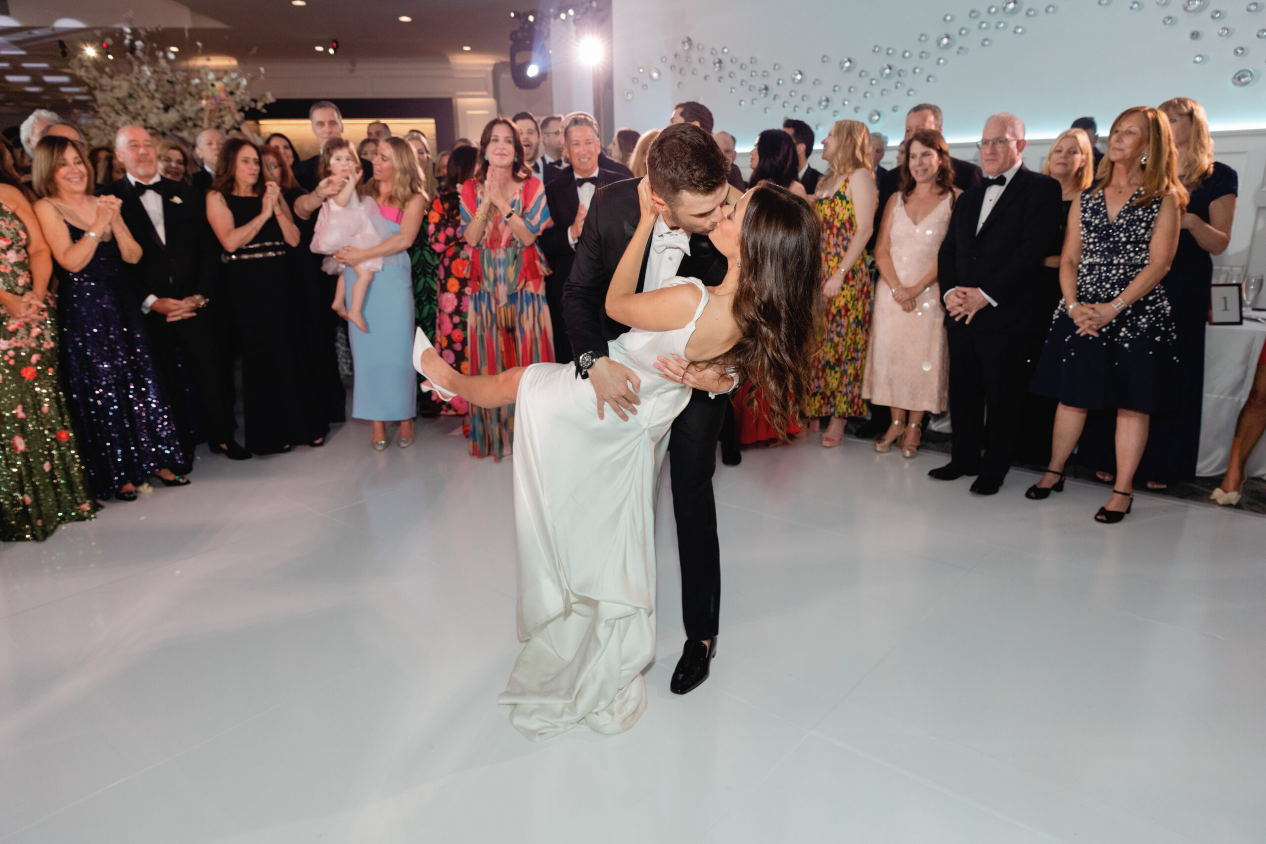 Bride and Groom on Dance Floor at Wedding Surrounded by Guests 