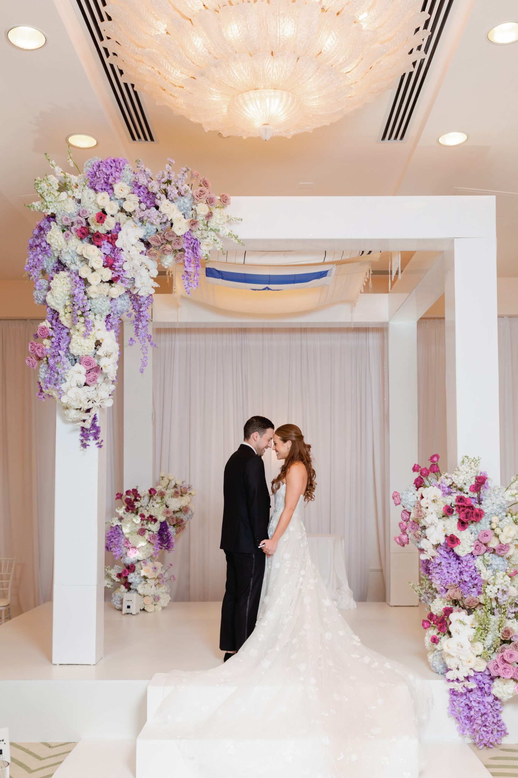 Bride and Groom Embrace Under Chuppah at Four Seasons Resort Palm Beach Wedding
