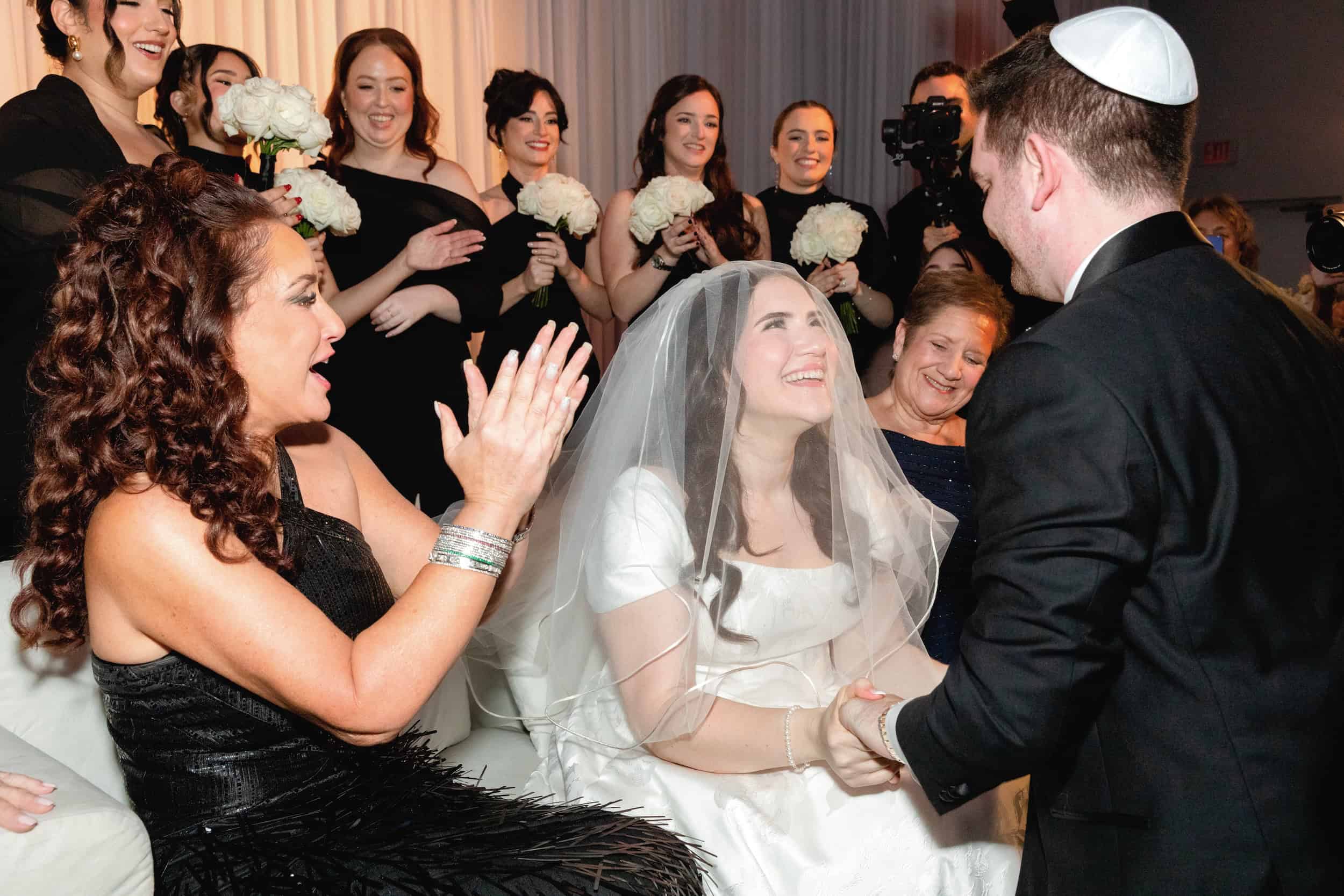 Bride and groom exchanging vows surrounded by joyful guests at a wedding celebration.