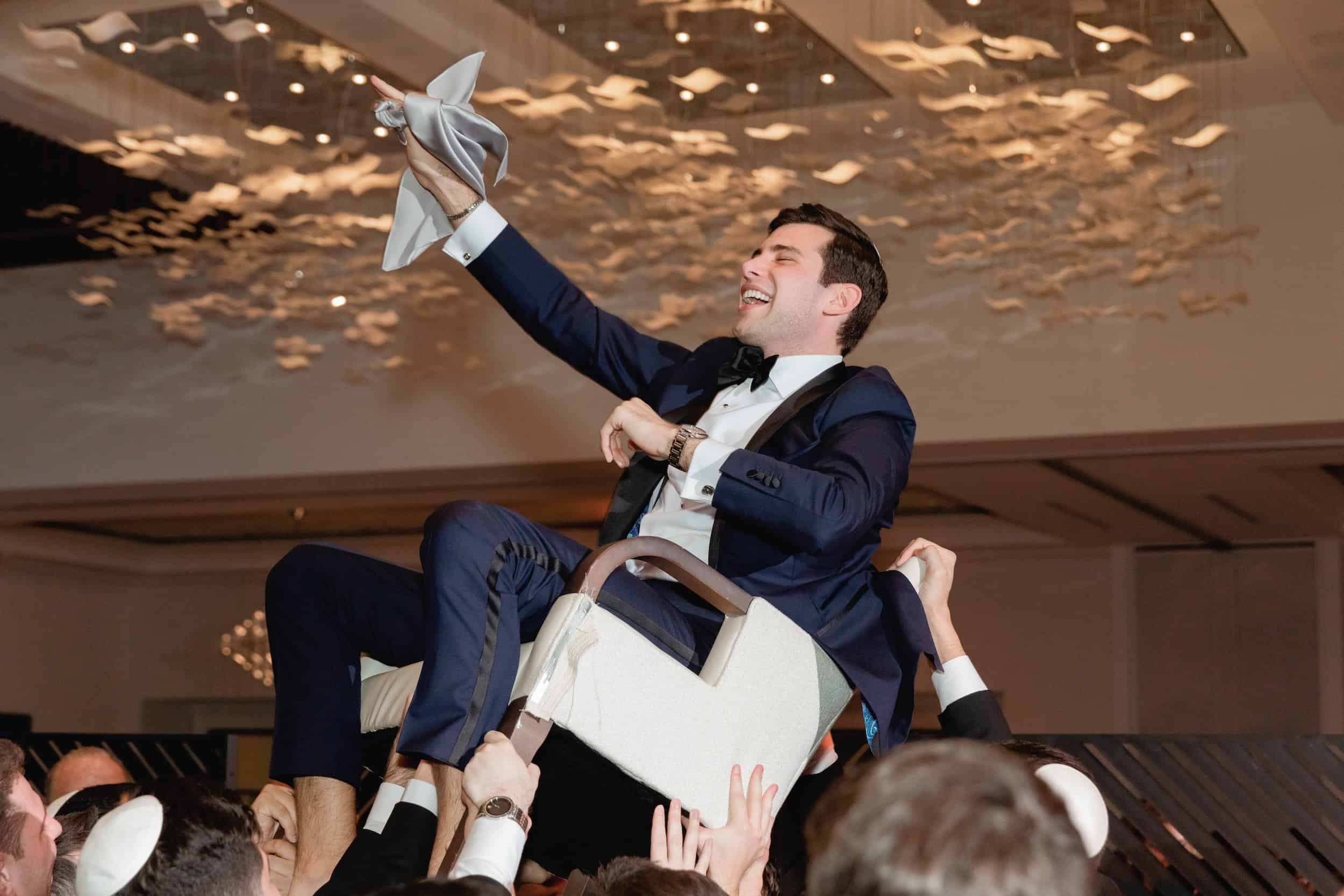 Groom Lifted on Chair at Jewish Wedding Hora