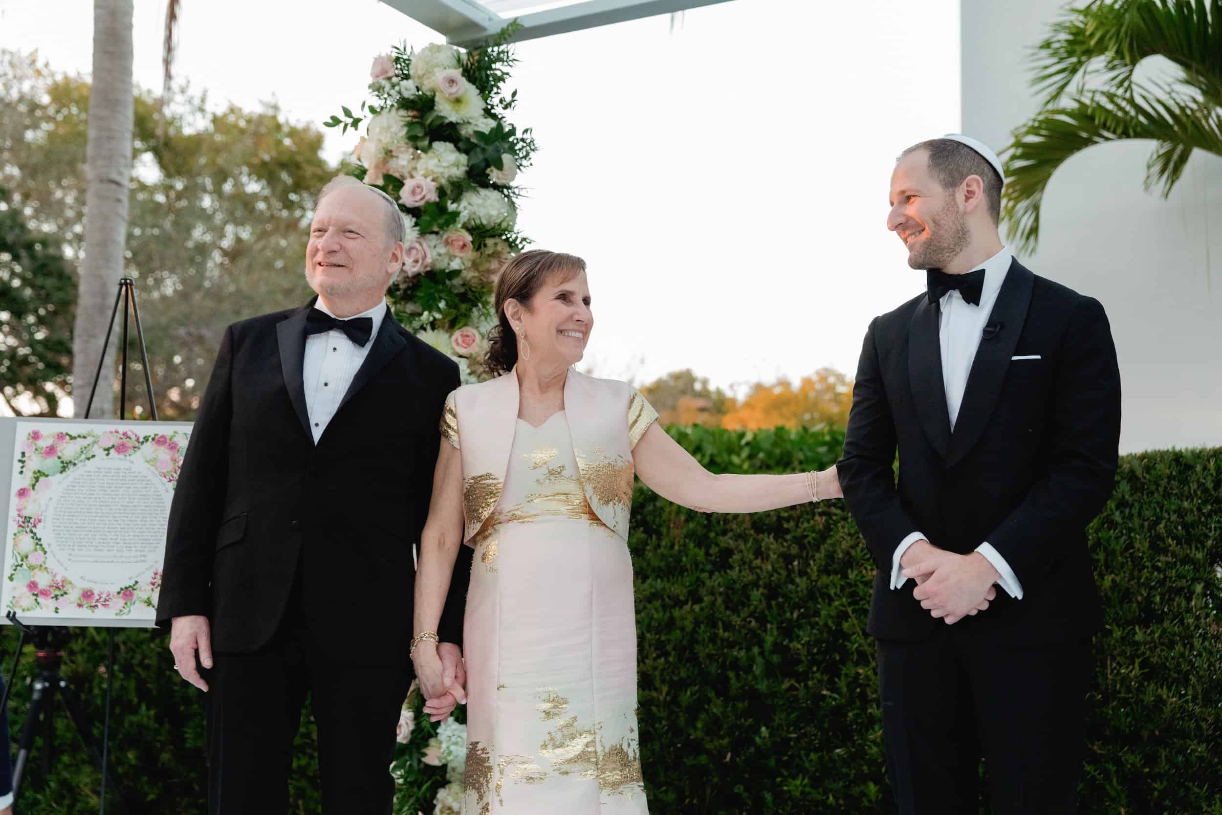 Mother and Father Walking Groom Down Aisle at Jewish Wedding
