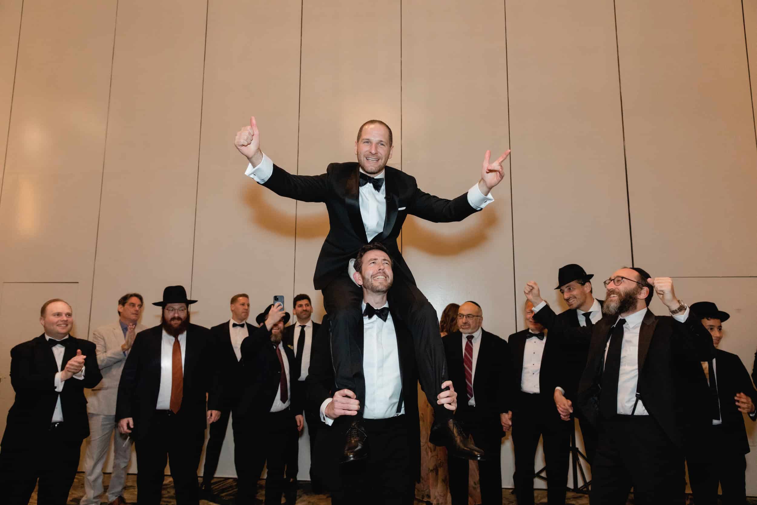 Groom Being Carried to Meet his Bride at Jewish Wedding
