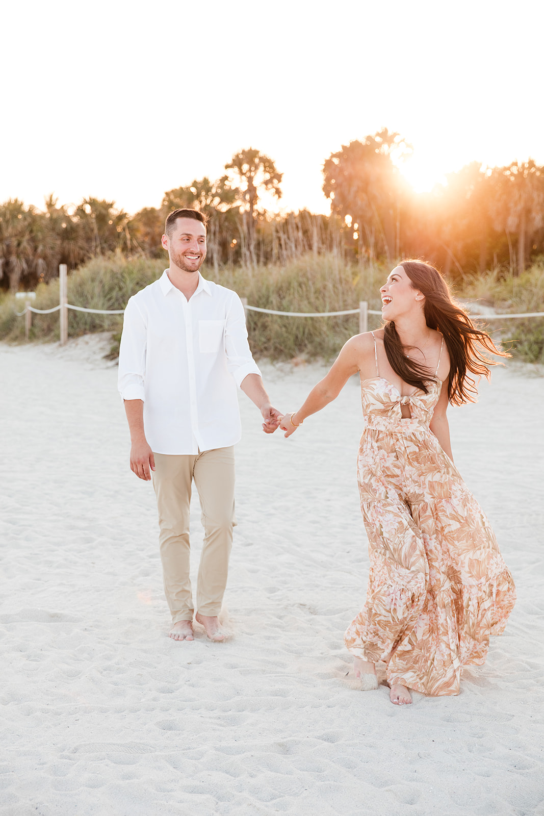 Engaged Couple Holds Hands Walking Through Sands of Miami Beach